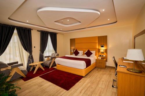 a hotel room with a bed and a desk at Watercress Hotels and Event in Ikeja