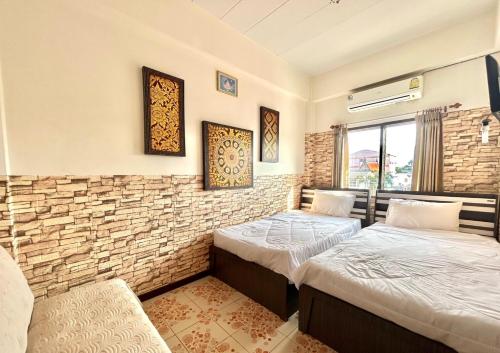 two beds in a room with a brick wall at Home One Love Ayutthaya GH in Phra Nakhon Si Ayutthaya