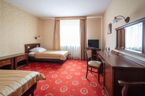 a hotel room with two beds and a desk and a desk at Anin Park Hotel in Warsaw