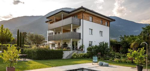 a large white house with mountains in the background at Haus Wiesenstein in Lana