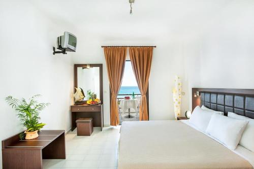 Postel nebo postele na pokoji v ubytování Xenios Dolphin Beach Hotel