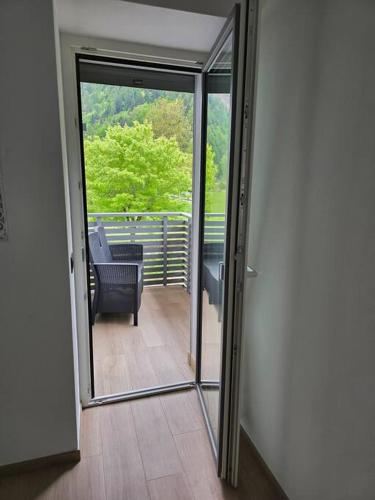 a glass door leading to a balcony with a chair at Appartamenti a Lases in Albiano