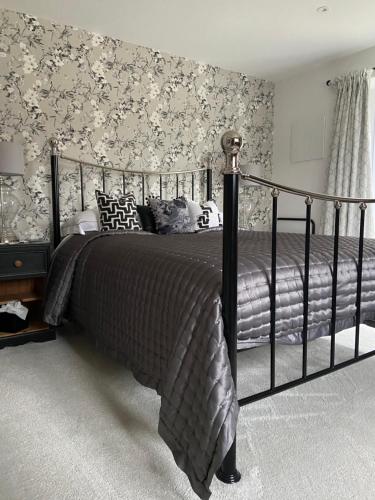 a bedroom with a large bed with floral wallpaper at Abbey Green Farm in Wem