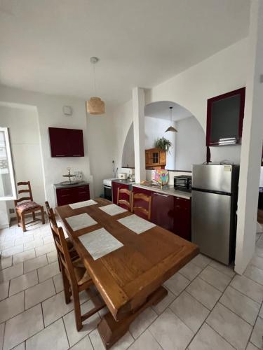 La cuisine est équipée d'une table en bois et d'un réfrigérateur en acier inoxydable. dans l'établissement Maison Châtillon sur Loire, à Châtillon-sur-Loire