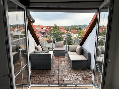 a balcony with couches and a view of a city at Schöne neue DG Wohnung mit sonniger Dachterrasse und fantastischem Ausblick in Naumburg