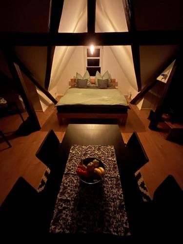 a room with a bed and a bowl of fruit on the floor at Schöne neue DG Wohnung mit sonniger Dachterrasse und fantastischem Ausblick in Naumburg