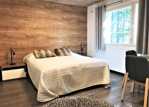 Un dormitorio con una cama y una pared de madera. en Vuokatti Weekend Studio, en Vuokatti
