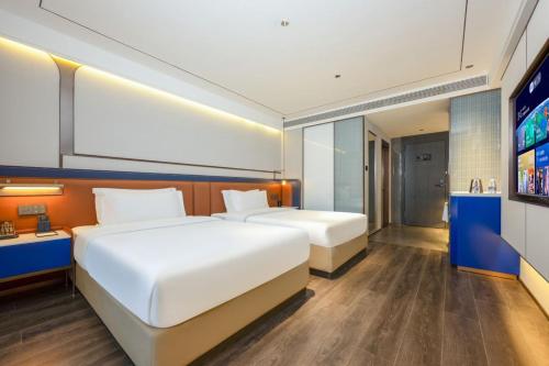 西安市にあるMehood Hotel Xi'an Tumen Railway Stationのベッド2台と薄型テレビ付きのベッドルーム
