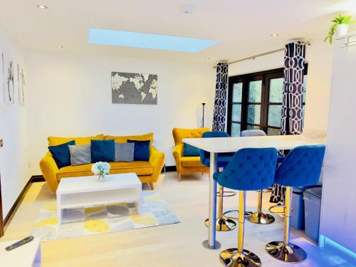 a living room with a yellow couch and a table at Fairy Meadows Hideaway in Peterborough