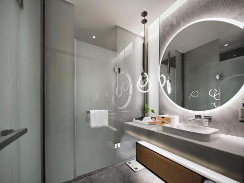 a bathroom with a sink and a mirror at EVEN Hotel Nanjing Yangtze River by IHG in Nanjing