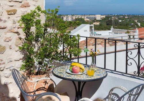 a table with a plate of fruit on a balcony at Art Boutique La Casona de las Flores in Ondara