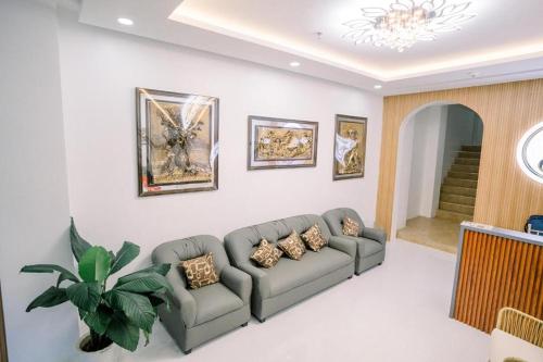 a living room with a couch and a potted plant at Spotlight Hotel near Hundred Islands Wharf in Alaminos