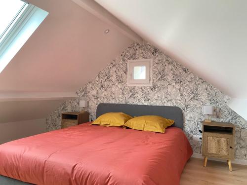 - une chambre avec un lit rouge et deux oreillers jaunes dans l'établissement Le Duplex - Massy Centre, à Massy