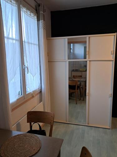 un salon avec une table et une grande fenêtre dans l'établissement Le porquerolle, à Bagnoles-de-l'Orne