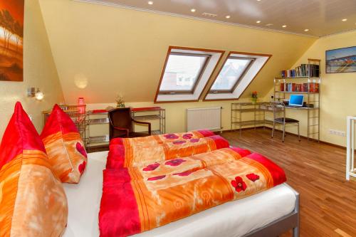 ein Schlafzimmer mit einem großen Bett mit orangefarbener und roter Bettwäsche in der Unterkunft Appartements DW16~17~19 in Dortmund in Dortmund