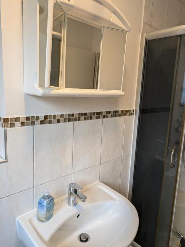 a bathroom with a sink and a mirror and a shower at NestOaseWHV Zentrale Zimmer zwischen City und Südstrand in Wilhelmshaven