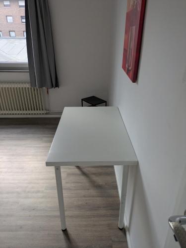 a white table in a room with a window at NestOaseWHV Zentrale Zimmer zwischen City und Südstrand in Wilhelmshaven