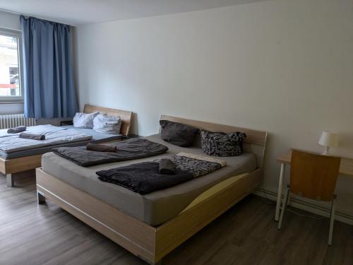 a bedroom with two beds and a desk and a window at NestOaseWHV Zentrale Zimmer zwischen City und Südstrand in Wilhelmshaven