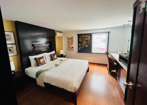 a bedroom with a large bed with a black headboard at Baipho Lifestyle in Patong Beach