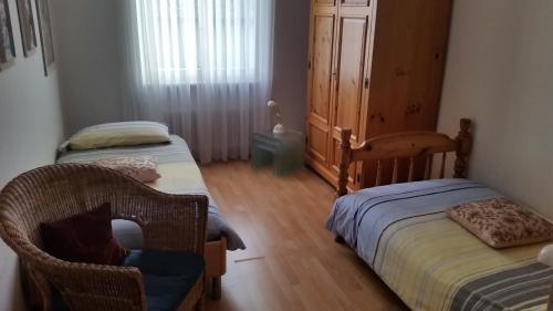 ロカルノにあるCasa Angelaのベッドルーム1室(ツインベッド2台、椅子付)