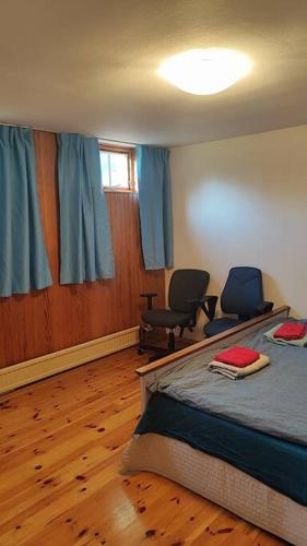 a bedroom with a bed and two chairs in it at nice apartment in Viby in Sollentuna