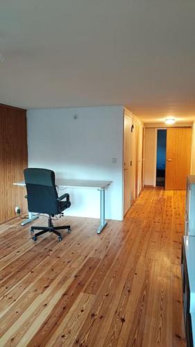 an office with a desk and a chair on a wooden floor at nice apartment in Viby in Sollentuna