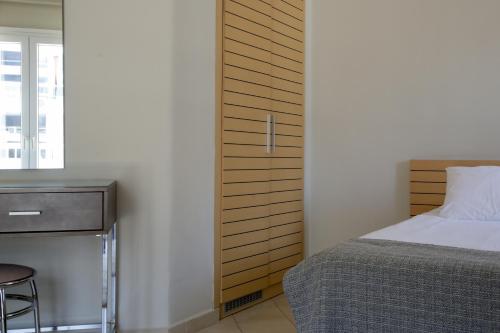 a bedroom with a bed and a table and a window at Astoria Hotel Thessaloniki in Thessaloniki