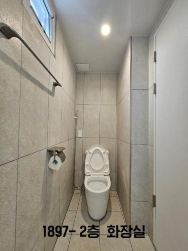 a small bathroom with a toilet in a stall at Yachtie Inn 1897 in Mokpo