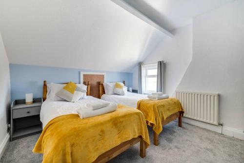 a bedroom with two beds with yellow blankets at Coble House Filey in Filey