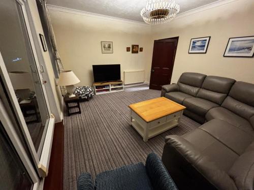 a living room with a couch and a tv at Coble House Filey in Filey