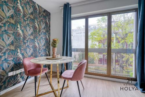 une table et deux chaises dans une pièce avec une fenêtre dans l'établissement Le Noble - À Neuilly-sur-Seine - 330B, à Neuilly-sur-Seine