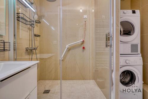 La salle de bains est pourvue d'une cabine de douche et d'un lave-linge. dans l'établissement Le Noble - À Neuilly-sur-Seine - 330B, à Neuilly-sur-Seine