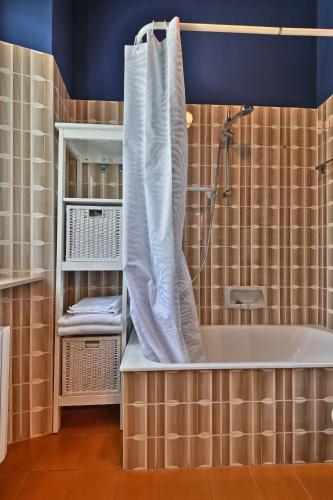 a bathroom with a bath tub with a shower curtain at Al Pos - Theater Home in Gargnano
