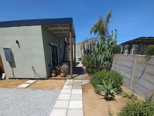 a house with a fence and some plants at The Den On Plover in Velddrif