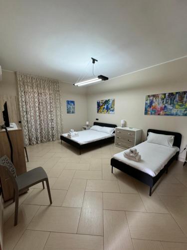 Villa Carmela - Elegante villa immersa nel verde في ماريليانو: غرفه سريرين وكرسي فيها