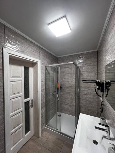 a bathroom with a shower and a sink at Садиба Магнолія in Tukhlya