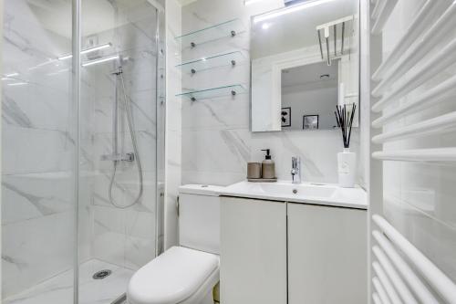 a white bathroom with a shower and a sink at T2 à 10min de Paris l Proche des Transports in Charenton-le-Pont