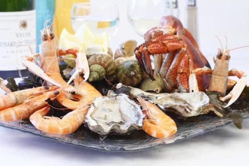 a plate of shrimp and other seafood on a table at Aux 13 Arches-Logis Hôtel Restaurant in Portbail