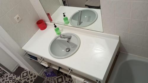 a white sink in a bathroom with a mirror at 3-7 Centre Ville in Montauban