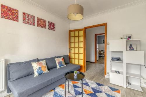 un salon avec un canapé bleu et une table dans l'établissement R'Apparts T4 Esprit Bicolore, à Saint-Martin-dʼHères