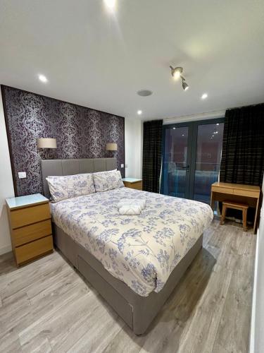a bedroom with a large bed and a desk at Cosy City Centre Location, Hydro Massage Showe in Manchester
