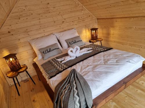 a bedroom with a bed in a log cabin at RYKOWISKO Kampinosek in Korbielów