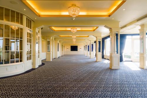 an empty hallway in a building with a chandelier at Grand Hotel Huis ter Duin in Noordwijk aan Zee