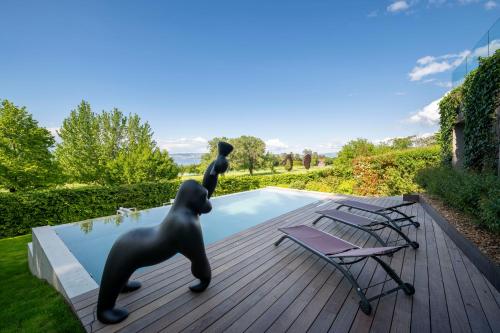 - une piscine avec une statue d'ours et 2 chaises dans l'établissement Maison du Golf, à Publier