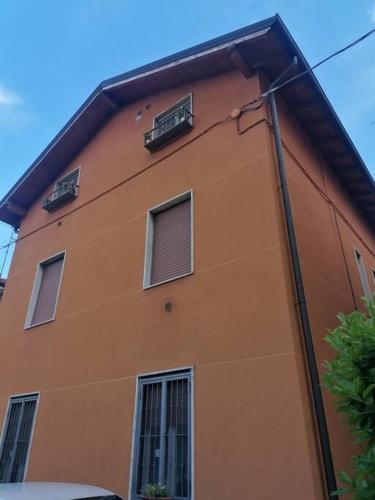 a orange building with three windows on the side of it at Luminoso Bilocale 5 Minuti da Linate in Pioltello