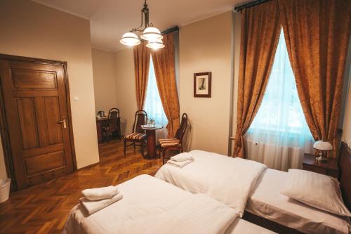 a bedroom with two beds and a window at Pałac Sieniawa in Sieniawa