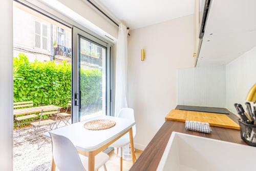 une cuisine avec une table blanche et une fenêtre dans l'établissement Lavie Maison Studio avec Jardin, à Bordeaux