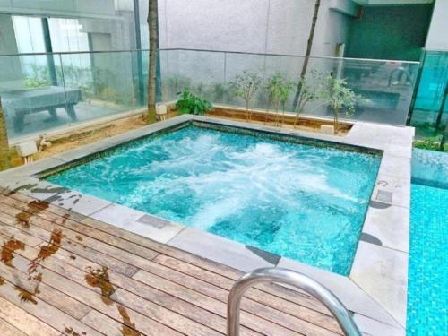 a large swimming pool with a wooden deck at Mercu Summer Suites Kuala Lumpur Bukit Bintang By Classy in Kuala Lumpur