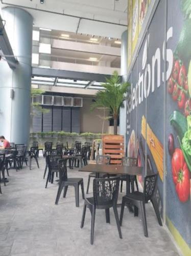 a dining area with tables and chairs in a building at Mercu Summer Suites Kuala Lumpur Bukit Bintang By Classy in Kuala Lumpur