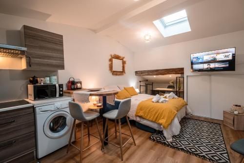 Il comprend une chambre avec un lit et une cuisine équipée d'un lave-linge. dans l'établissement Marie-Rose au Faubourg - Charmant studio en plein cœur de Montauban, à Montauban